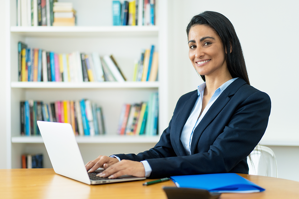 Registrar on laptop smiling