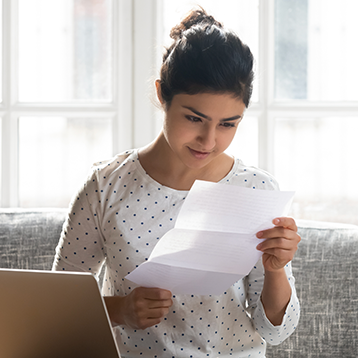 Young female looking at transcripts paper