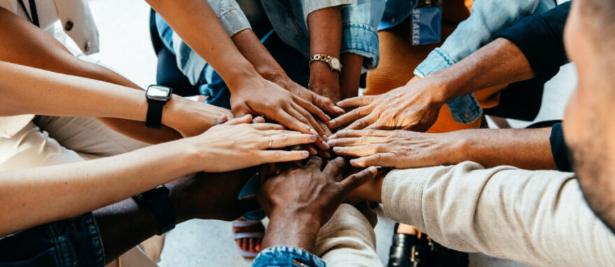 Teamwork concept with diverse hands joining together, symbolizing unity, cooperation, and collaboration